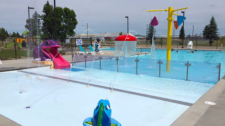 Tioga Swimming Pool's outdoor leisure pool with zero depth beach entry, frog water slide, barrier wall, and spray features